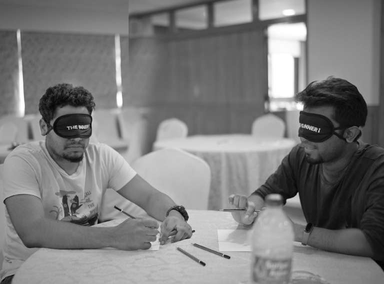 Workshop page for Strategy with Meenu at BIC 1 a man sitting at a table with a blindfold on his eyes